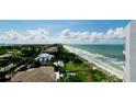 Aerial view of a beach and ocean, with houses visible in the background at 1000 Longboat Club Road # 1103, Longboat Key, FL 34228