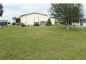 Lush backyard with green lawn and mature tree, providing ample space for outdoor enjoyment at 6064 Shearwater Dr, Englewood, FL 34224