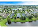 A beautiful aerial view of a house surrounded by a scenic landscape with a pond and neighborhood at 12198 Longview Lake Cir, Bradenton, FL 34211