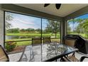 A screened patio has seating and a grill with views of the backyard and pond at 12198 Longview Lake Cir, Bradenton, FL 34211