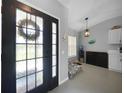 Bright entryway featuring a decorative wreath, stylish pendant lighting, and a view into the adjacent room at 2204 Chipley Ave, North Port, FL 34286