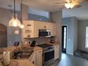 Bright kitchen featuring stainless steel appliances, stove, microwave, pendant lights and a breakfast bar with light countertops at 2204 Chipley Ave, North Port, FL 34286