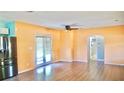 Open-concept living area with laminate flooring, a ceiling fan, and a doorway leading to the hallway and bathroom at 5415 5Th N Ave, St Petersburg, FL 33710