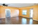 Spacious living area with light brown laminate flooring, and a view of the bathroom and backyard through sliding glass doors at 5415 5Th N Ave, St Petersburg, FL 33710