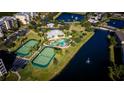 Aerial view of community pool, tennis courts, and lake at 9947 Key Haven Rd, Seminole, FL 33777