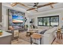 Stunning living room with a decorative fireplace, wood ceiling beams, and an expansive window overlooking the backyard at 13212 Deep Blue Pl, Lakewood Ranch, FL 34211