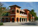 Exterior view of a vibrant marketplace with arched entryways and palm trees at 1876 Magnolia St, Sarasota, FL 34239