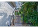 Backyard access with a black metal gate and landscaping at 7823 33Rd E St # 20, Sarasota, FL 34243