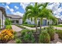 Landscaped walkway leading to home with lush tropical plants at 14594 Mossy Pine Ct, Nokomis, FL 34275