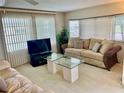 Living room with beige sofa and glass-top coffee tables at 1806 Brook Field Ter, Sarasota, FL 34234