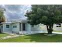 Light blue manufactured home with landscaped yard at 1806 Brook Field Ter, Sarasota, FL 34234