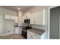 Modern kitchen with white cabinets, granite counters, and stainless steel appliances at 2624 Averland Loop, North Port, FL 34287