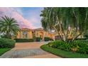 Mediterranean style home with palm trees and circular driveway at 909 Macewen Dr, Osprey, FL 34229