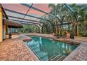 Screened pool and spa with brick pavers and covered patio area at 909 Macewen Dr, Osprey, FL 34229
