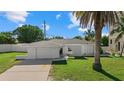 White single-story house with a garage and palm trees in the front yard at 1160 Morningside Pl, Sarasota, FL 34236
