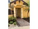 Inviting home entrance with brick walkway, yellow exterior, and lush landscaping at 6414 Moorings Point Cir # 201, Lakewood Ranch, FL 34202