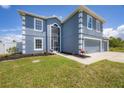 Two-story house with gray siding, white trim, screened porch, and attached two-car garage at 14312 Barbarossa Ln, Port Charlotte, FL 33981