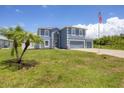 Two-story house with a two-car garage and landscaped lawn at 14312 Barbarossa Ln, Port Charlotte, FL 33981