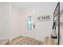 Bright entryway with wood-look floors, bench, and coat rack at 11868 Little River Way, Parrish, FL 34219