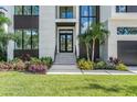 Modern home entrance with landscaping and a two-car garage at 214 S Renellie Dr, Tampa, FL 33609