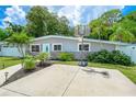 Modern home exterior with a teal door, stone accents, and a basketball court at 936 Charlotte Ave, Sarasota, FL 34237