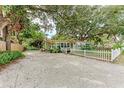 Exterior view of the house surrounded by lush trees and a spacious driveway at 1533 1St Ave W Dr, Bradenton, FL 34205
