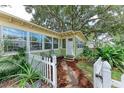 Inviting entrance with a white picket fence, lush foliage, and a quaint pathway to the front door at 1533 1St Ave W Dr, Bradenton, FL 34205