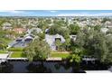 Expansive aerial view of a home with a dock on a canal with mature landscaping and solar panels at 4532 Shark Dr, Bradenton, FL 34208