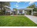 Charming home with manicured lawn, lush landscaping, and covered parking at 4532 Shark Dr, Bradenton, FL 34208
