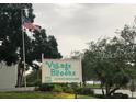 Village Brooke Condominiums sign with American flag at 3271 Beneva Rd # 204, Sarasota, FL 34232