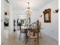 Elegant dining room with chandelier and glass-top table at 302 Mendez Dr, Sarasota, FL 34243