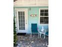 Inviting front porch with teal chairs and unique decor at 1603 Gulf N Dr # 5, Bradenton Beach, FL 34217