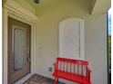 Inviting entryway with a red bench and a glass door at 224 Babbling Brook Run, Bradenton, FL 34212