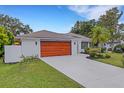 White brick home with a wood-toned garage door and nicely landscaped yard at 891 Faulkwood Ct, Sarasota, FL 34232