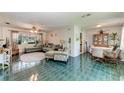 Open living room with green tile floors, sofa, and dining area at 1410 21St W St, Bradenton, FL 34205