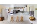 Galley kitchen with white cabinets, stainless steel appliances, and breakfast bar at 1926 Crampton Ave, Sarasota, FL 34235