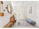 Light and airy entryway with a bench, mirror, and rug at 2803 Butterfly Jasmine Trl, Sarasota, FL 34240