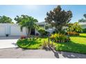 Neatly landscaped home with a white garage, driveway, and lush greenery at 1315 Westport Ln # 1412, Sarasota, FL 34232