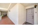 Neutral color hallway leading to unit 310 with unique architectural design and brick flooring at 1945 Gulf Of Mexico Dr # M2-310, Longboat Key, FL 34228