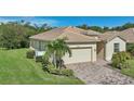 One-story house with a two-car garage, palm trees, and manicured lawn at 1480 Mossy Oak Dr, North Port, FL 34287