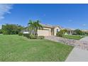 One-story house with a two-car garage and lush green lawn at 1480 Mossy Oak Dr, North Port, FL 34287