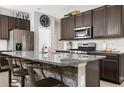 Modern kitchen with dark cabinets, granite countertops, and an island with seating at 5619 Los Robles Ct, Palmetto, FL 34221