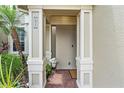 Inviting front entry with brick walkway, columns, and potted plants at 7922 Tybee Ct, University Park, FL 34201