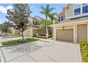 Tan two-story townhome with two-car garage and lush landscaping at 7922 Tybee Ct, University Park, FL 34201
