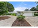 Charming home with a metal roof, lush landscaping, and a concrete driveway at 5307 2Nd Avenue Nw Dr, Bradenton, FL 34209