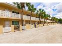 Tan colored building with palm trees and white railings at 5955 Midnight Pass Rd # 12E, Sarasota, FL 34242