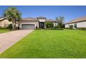 One-story home with gray garage door and manicured lawn at 4803 Cabreo Ct, Bradenton, FL 34211