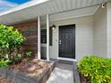 Front entrance with black door and custom wood feature wall at 2907 Marshall Dr, Sarasota, FL 34239