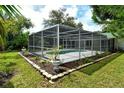 Screened-in pool area with lush landscaping at 4724 Seville Dr, Sarasota, FL 34235