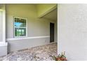Covered entryway with paver flooring and landscaping at 4254 Golden Creek Ter, Parrish, FL 34219